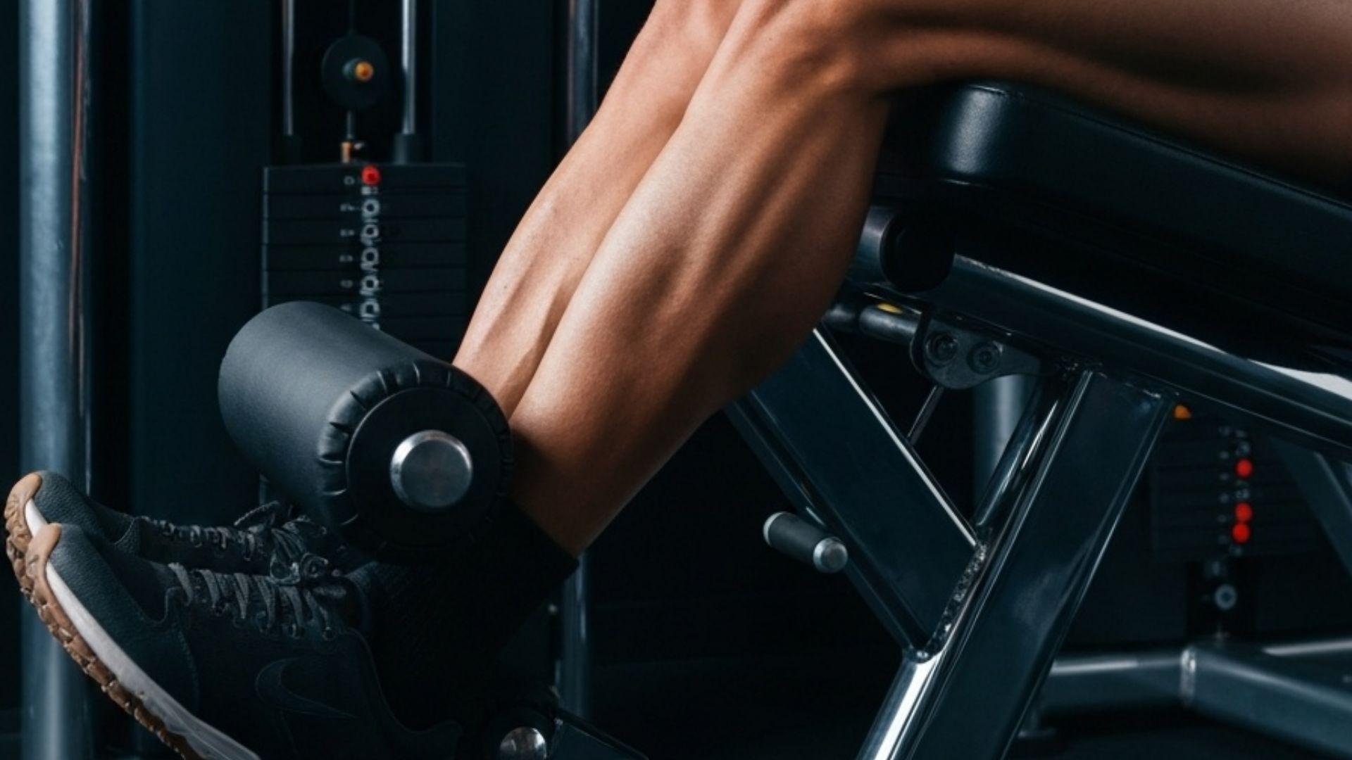 Person som utfører leg extension på maskin i treningsstudio med korrekt sittestilling og kontrollert bevegelse