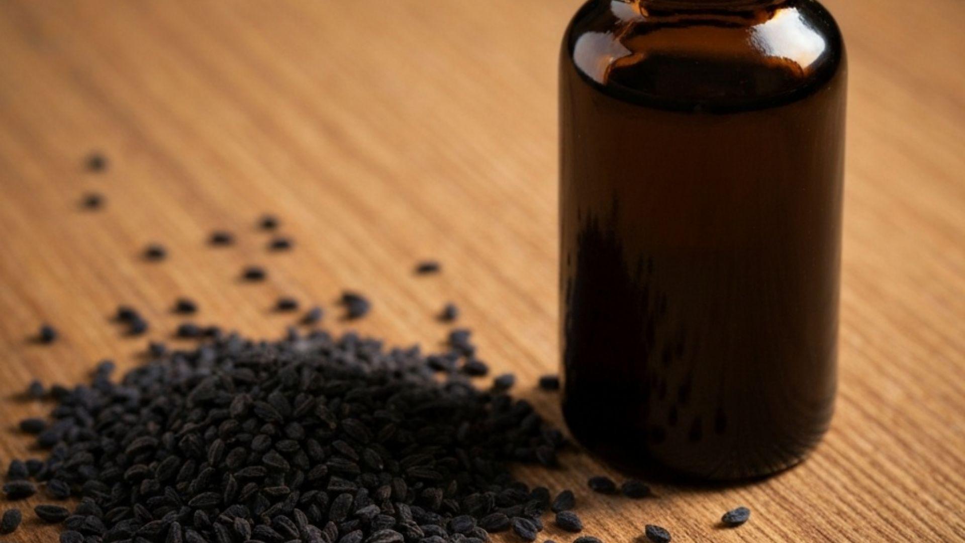 Svartfrøolje i glassflaske med nigella sativa frø