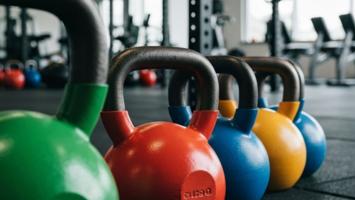 Fargerike competition kettlebells på rekke i treningsstudio