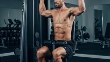 Mann trener lat pulldown på multigym i hjemmegym