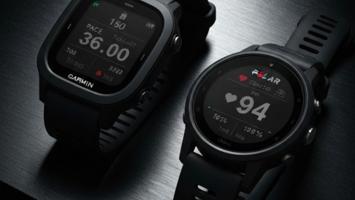 Sportsklokker fra Garmin og Polar på mørk overflate med glødende AMOLED-skjermer