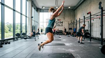 Person som gjør eksplosive burpees i treningsrom med energisk atmosfære
